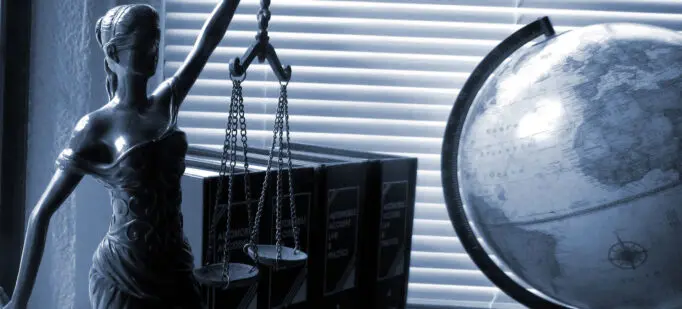 A blindfolded lady justice figurine holds a scale